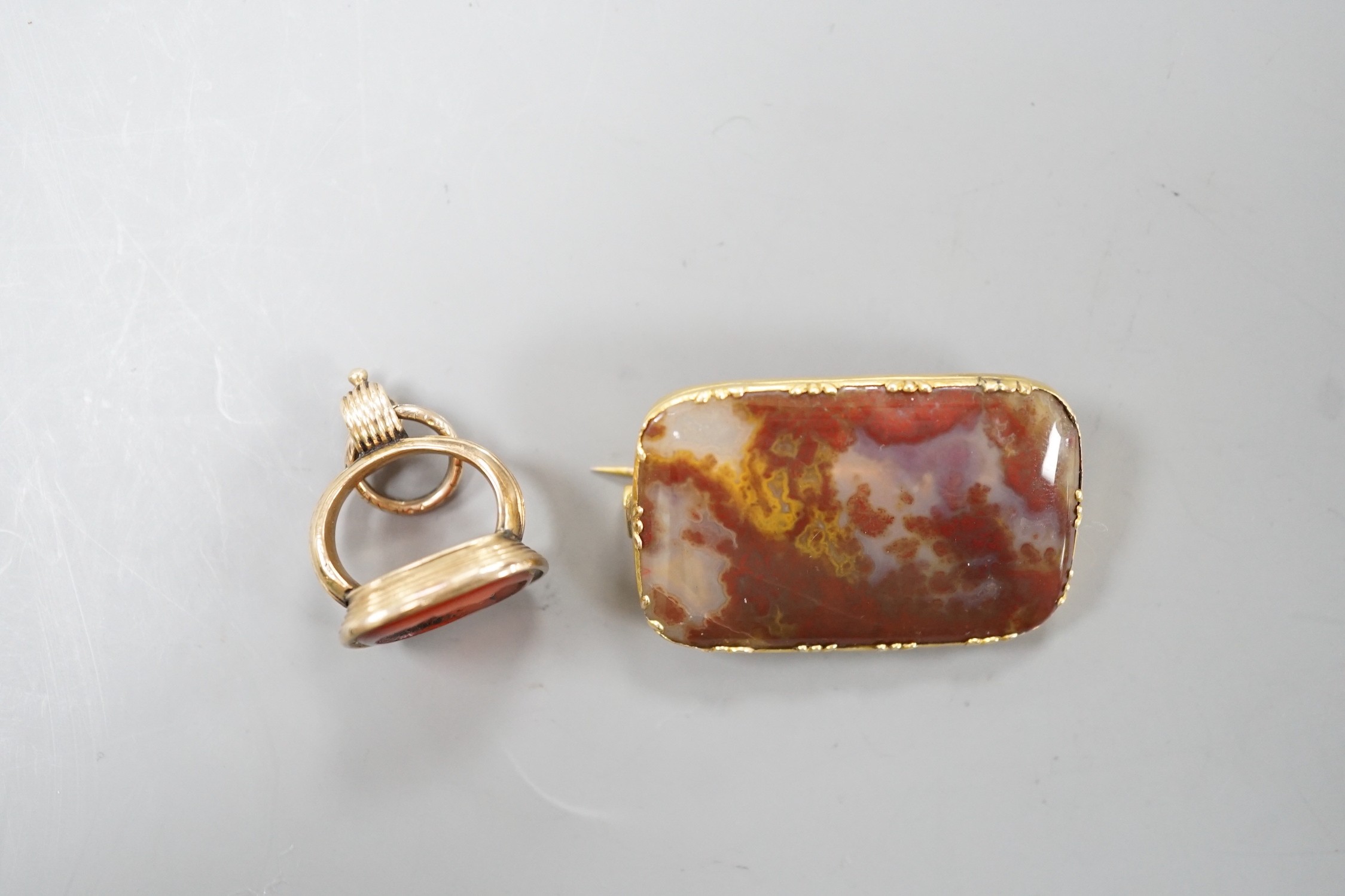 A Victorian yellow metal overlaid seal and and intaglio carnelian set seal, 21mm and a yellow metal and agate set brooch.